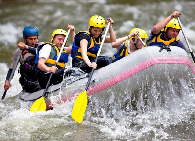 Group-of-people-paddling-while-whitewater-rafting-133831440_695x504.jpeg