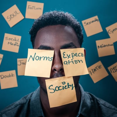 black man with post it notes over his face and wall